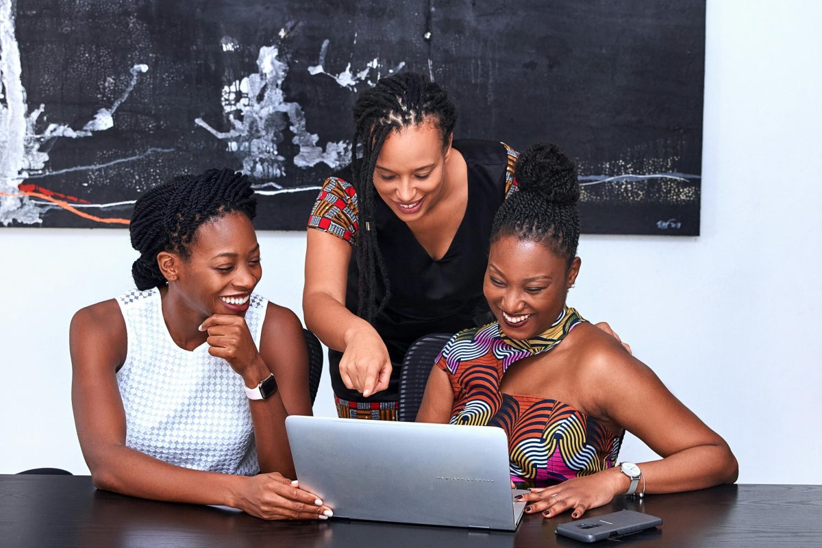 pexels-photo-3894378-3894378 Three African American women collaborating at a laptop, focused and happy during a meeting indoors.