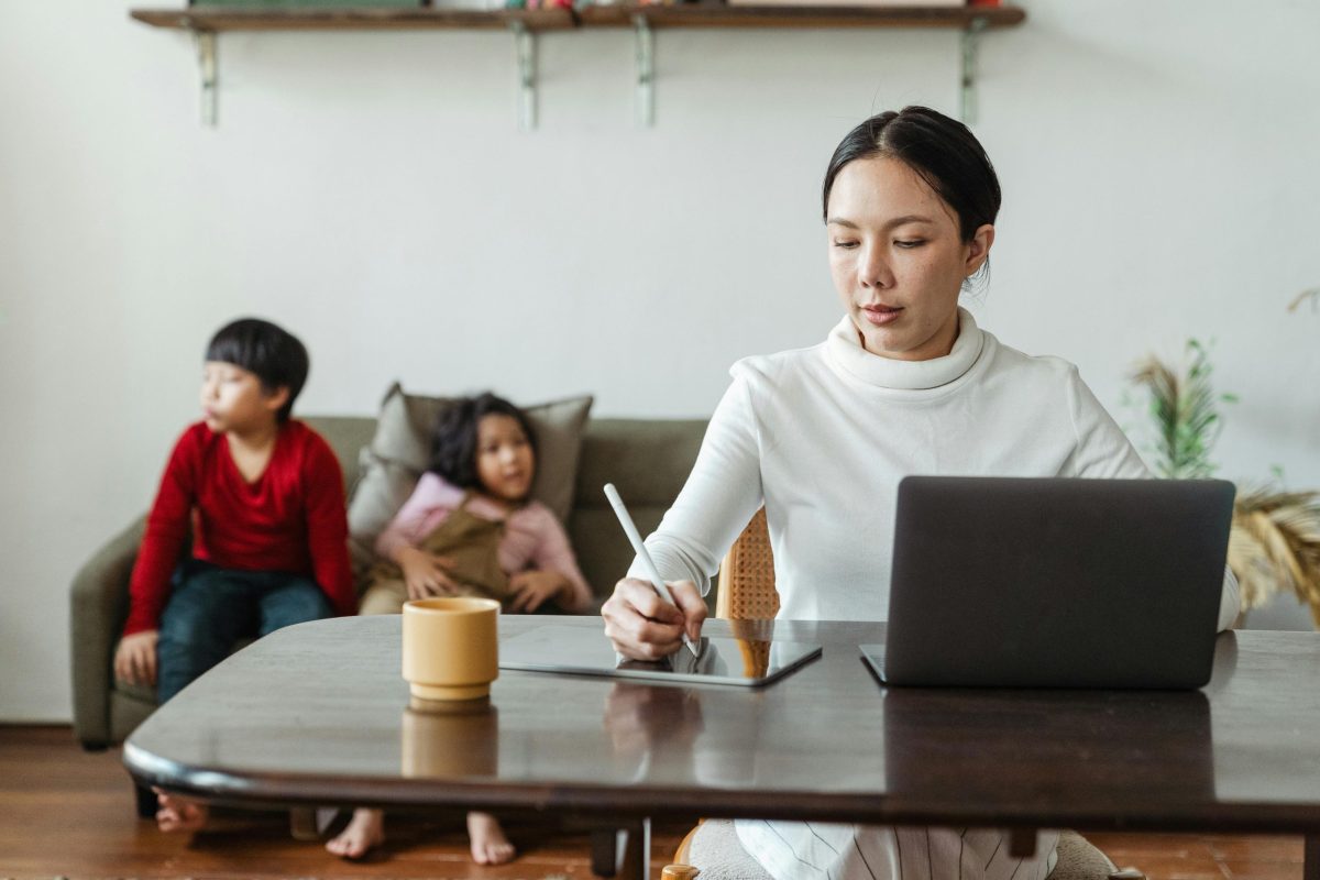 pexels-photo-4474041-4474041 Asian mother balances remote work while supervising children at home.